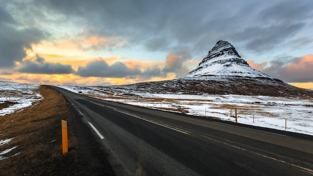 Droga do Kirkjufell pod chmurnym niebem przy półmrokiem