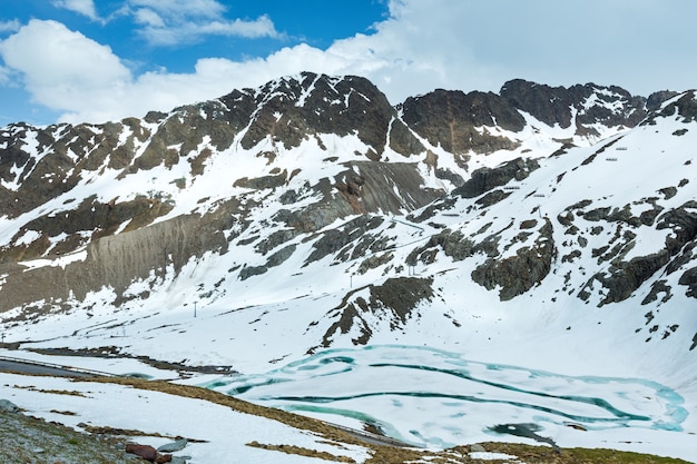 Droga latem w Alpach i zamarzniętym jeziorze (Austria).