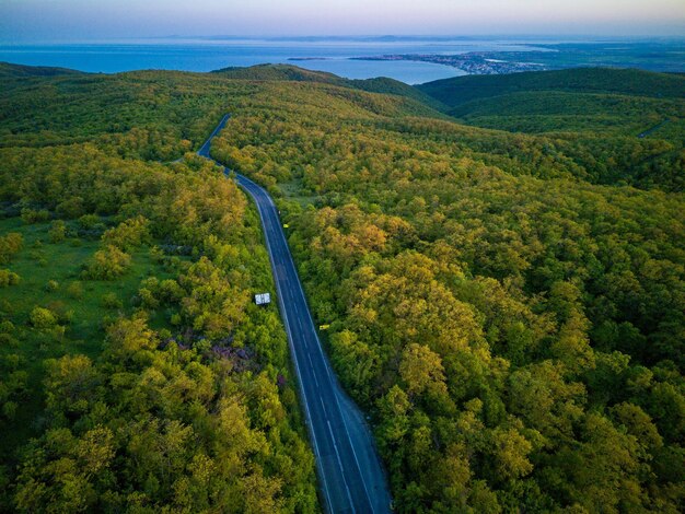 Droga samochodami i ciężarówkami prowadzi w dal między lasami na Bałkanach