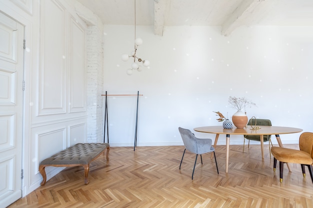 Drogi nowoczesny lekki luksusowy wystrój przestronnego salonu z drewnianymi elementami i białymi ścianami. wypełniony oryginalnymi i nietypowymi przedmiotami dekoracyjnymi