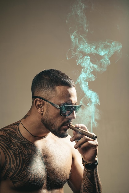 Drogi tytoniowy wytatuowany mężczyzna z palącym cygarem ciesz się chwilą życia brodaty muskularny macho bea