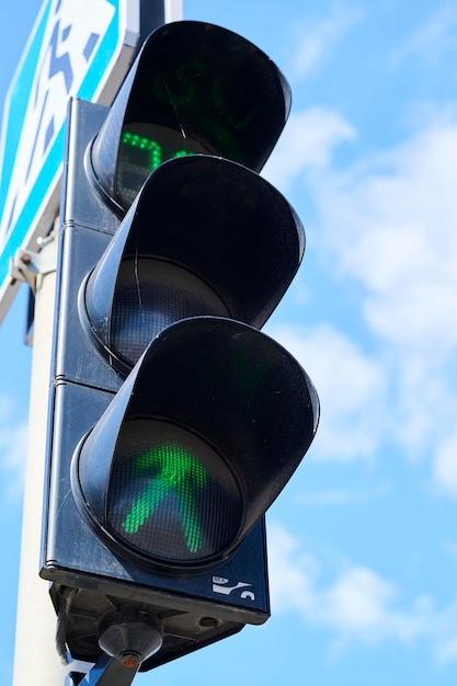 Drogowe zielone światła dla pieszych na tle błękitnego nieba znaki drogowe samochodu
