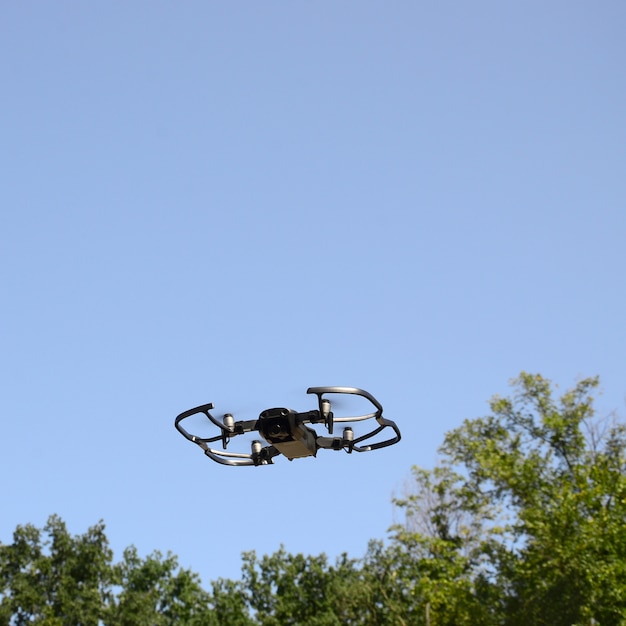 Dron z aparatem fotograficznym startuje z lądu i lata do zrobienia zdjęcia z lotu ptaka