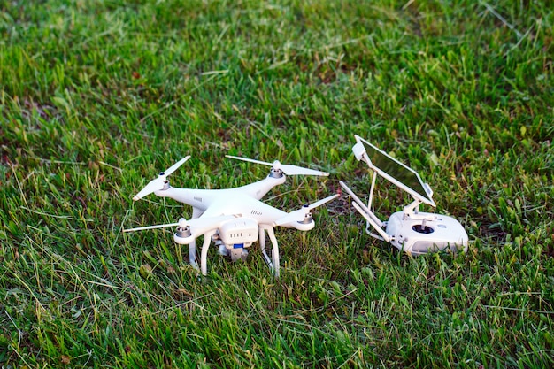 Drone quadter z cyfrowym aparatem o wysokiej rozdzielczości i pilotem ze smartfonem na trawie