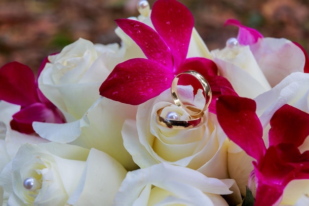 Druhna lub panna młoda trzyma bukiet jasnobiałych i różowawych róż na weselu