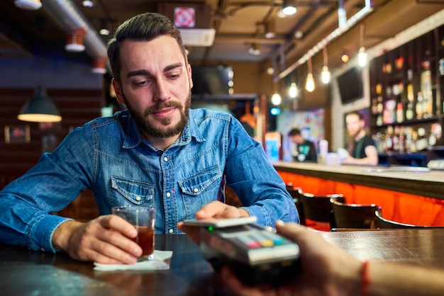 Drunk Man Paying via NFC in Pub