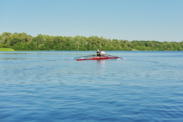 Drużyna dwóch nastoletnich chłopców pływających kajakiem po rzece. Aktywny styl życia młodzieży, sporty wodne, kajak, canoe