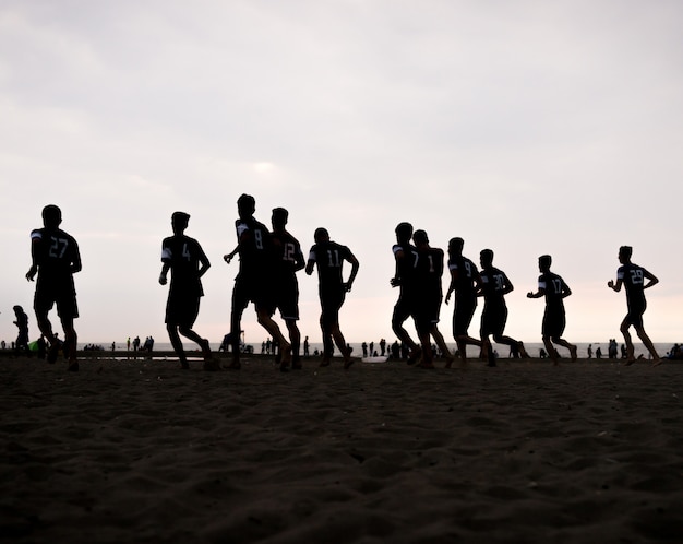 Drużynowy szkolenie młodzi chłopiec na zmierzch plaży