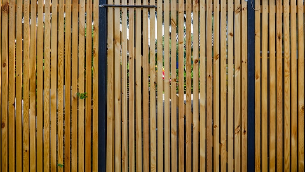 Drzwi w ogrodzeniu drewnianym wykonanym z pionowych listew.