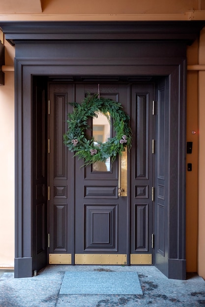 Drzwi wejściowe udekorowane bożonarodzeniowym wieńcem