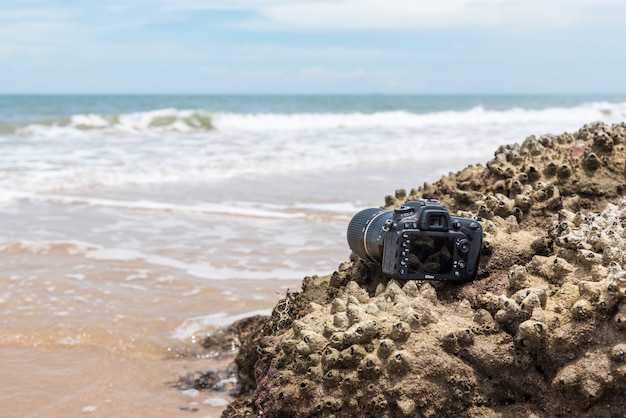 DSLR kamera na plaży mokrej od wodnej morze fala