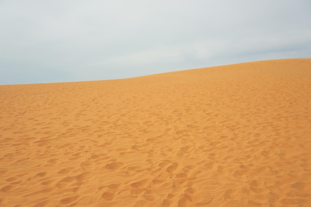 Zdjęcie duna piaskowa na pustyni z chmurami w tle