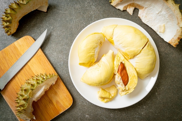 Durian dojrzały i świeży, skórka duriana na białym talerzu