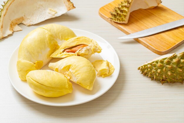 Durian dojrzały i świeży, skórka z duriana na białym talerzu
