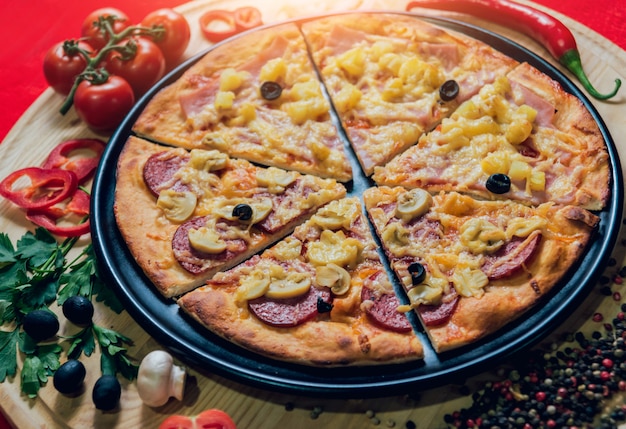 Zdjęcie duża gorąca pizza na czarnym talerzu.