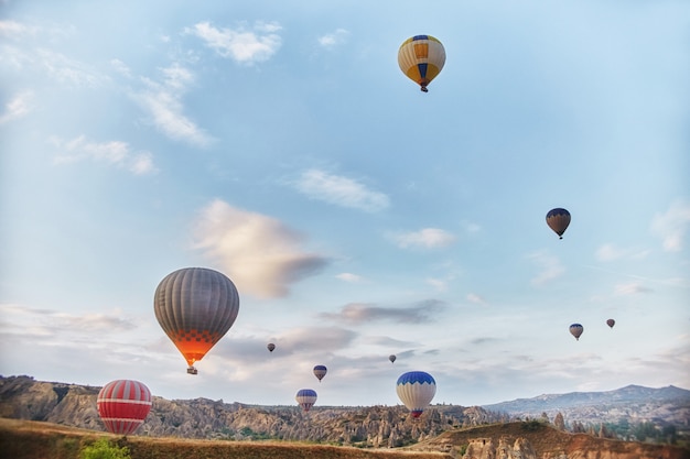 Duża liczba balonów lata rano w promieniach nieba