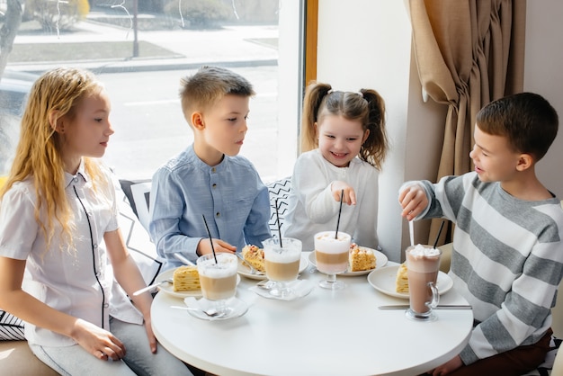 Duża Przyjazna Grupa Dzieci świętuje Wakacje W Kawiarni Z Pysznym Deserem. Dzień Urodzenia.
