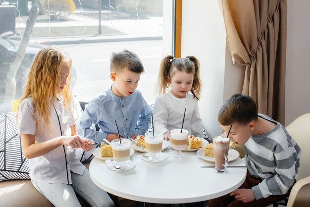 Duża Przyjazna Grupa Dzieci świętuje Wakacje W Kawiarni Z Pysznym Deserem. Dzień Urodzenia.