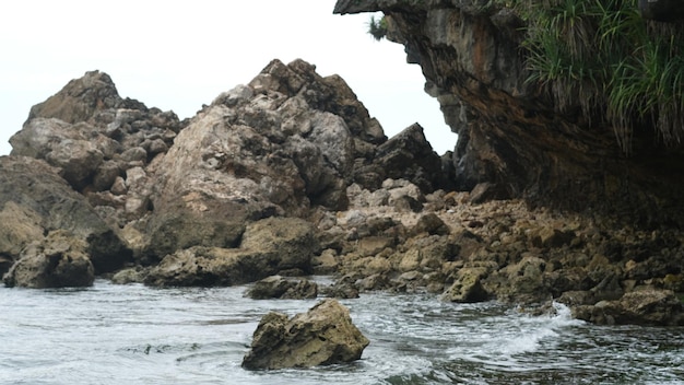 duża skała na skraju oceanu. skalista plaża z dużymi falami i czystą wodą. plaża w krasie.