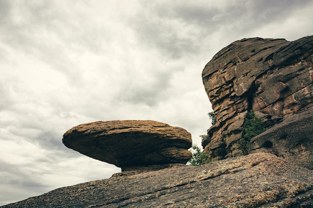 Duża skała w kształcie grzyba lub kształtu UFO pod szarym niebem
