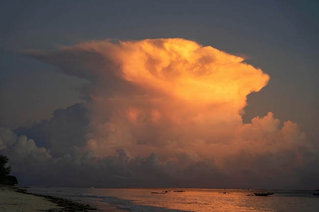 Duże białe chmury i niebo nad wodą morską na tropikalnej plaży podczas wschodu słońca na wyspie Zanzibar Tanzania Afryka Koncepcja podróży i przyrody