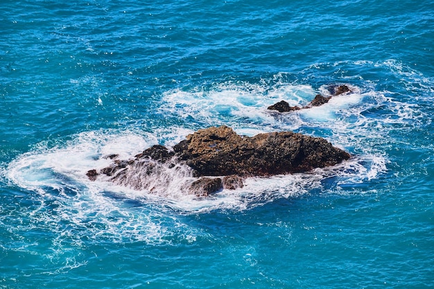 Duże skały w wodzie oceanu, o które uderzają fale