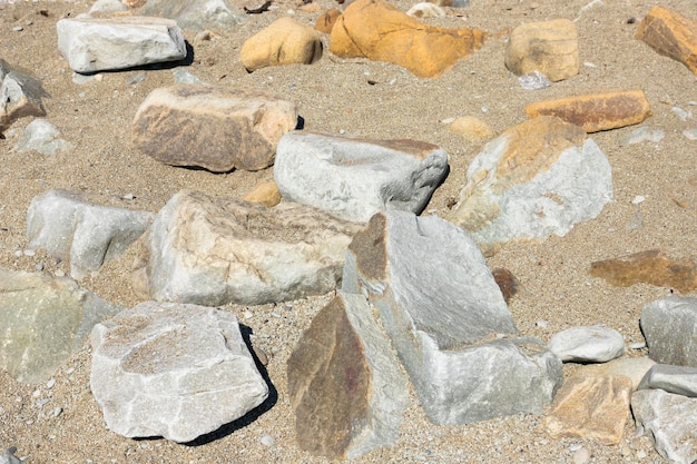 Duże szare i brązowe kamienie na plaży Tło