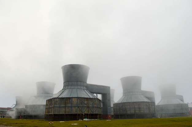 Duże wieże chłodnicze w wodzie i mgle w petrochemicznym zakładzie chemicznym rafinerii ropy naftowej