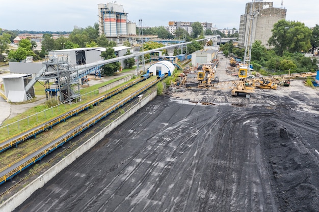 Duże zapasy węgla w elektrowni, wiele dźwigów rozładowujących węgiel, dużo węgla, widok z góry