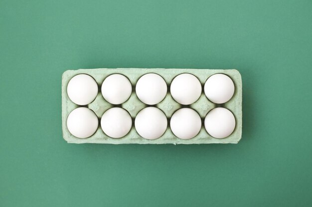Dużo białych jaj kurzych na kolorowym, równym i jasnym tle