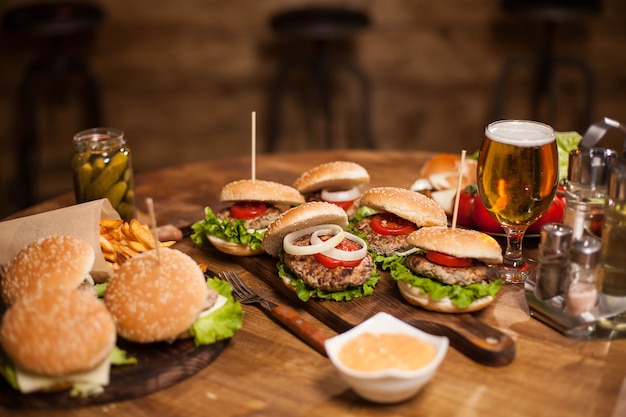 Dużo pysznych burgerów leżących na stole w vintage pubie lub restauracji