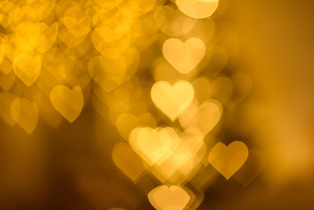 Zdjęcie dużo złotych światełek w kształcie serc nieostrych na ciemnym tle