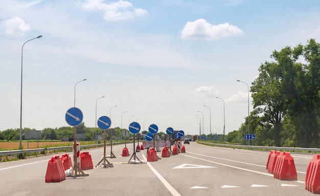 Dużo znaków drogowych wskazujących kierunki na autostradzie asfaltowej.