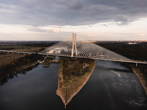 Duży biały wiszący most nad rzeką, po którym jeżdżą samochody we Wrocławiu, Polska wystrzelony z drona