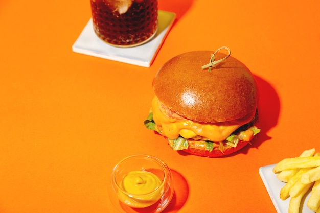 Duży Burger Z Frytkami I Sosem Na Jasnopomarańczowym I żółtym Tle Amerykański Fast Food Cui...