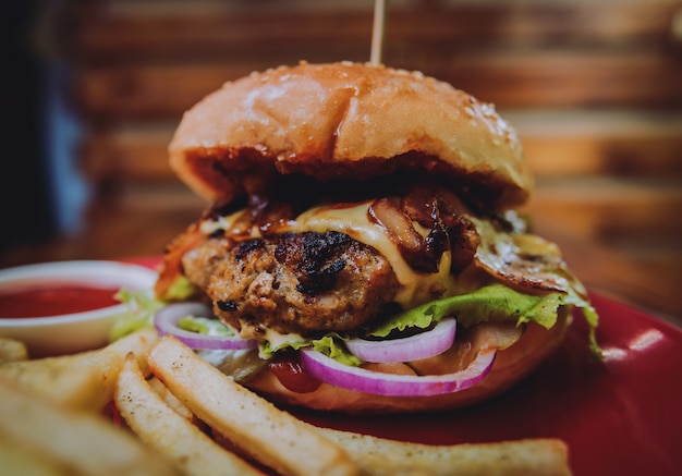 Duży cheeseburger i układ scalony na talerzu.