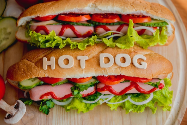 Duży hot dog z warzywami na stole.