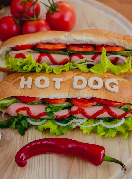 Duży hot dog z warzywami na stole.