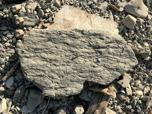 Duży kamień leży na kamyku morskim na plaży. kawałek skały. Zdjęcie wysokiej jakości