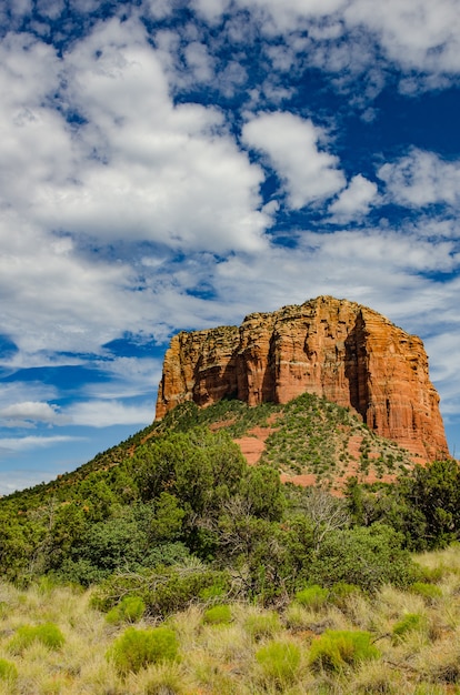 Duży klif przed drzewami pod błękitnym niebem pełnym chmur w Sedona, Arizona