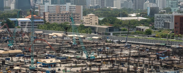 Duży plac budowy z ciężkimi maszynami budowlanymi w metropolii