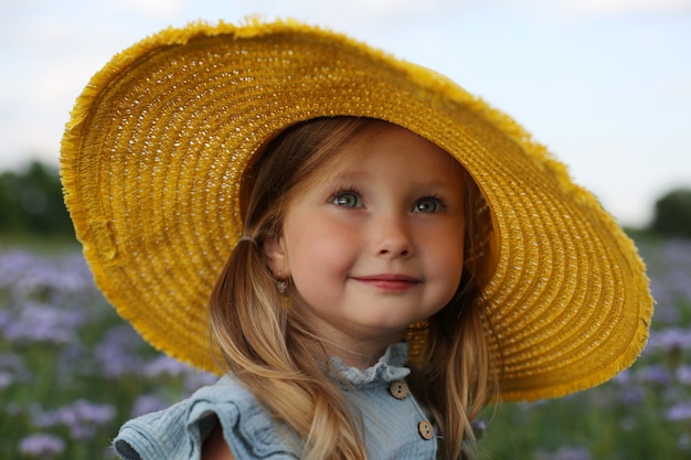 duży portret pięknej blondynki w żółtym kapeluszu