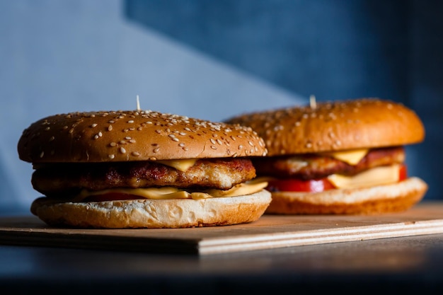Duży soczysty burger z kotletem serowym i pomidorami Fast food