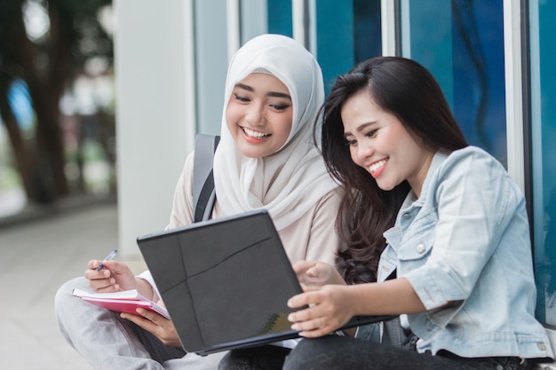 Dwa azjatykciego studenta collegu używa laptop