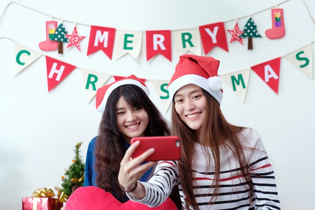 Dwa azjatykciej kobiety selfie mądrze telefon w przyjęcie gwiazdkowe świętowaniu