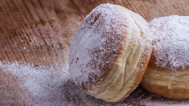 Dwa Berlińskie Pączki Posypane Cukrem Pudrem Na Drewnianym Tle.