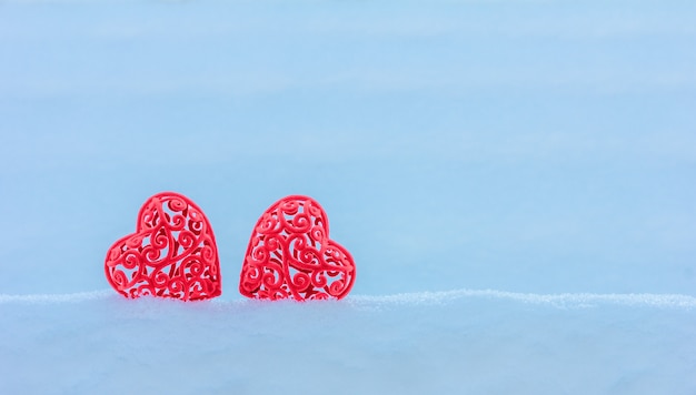 Dwa czerwone aksamitne serce w zaspie. Koncepcja Valentine