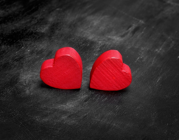 Dwa czerwone drewniane serca na czarno