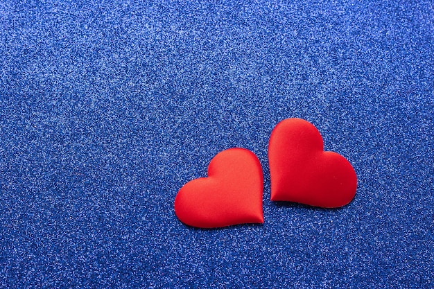 Dwa czerwone serca symbol miłości na błyszczącym niebieskim tle Koncepcja walentynki Przestrzeń kopii poziomej ramki