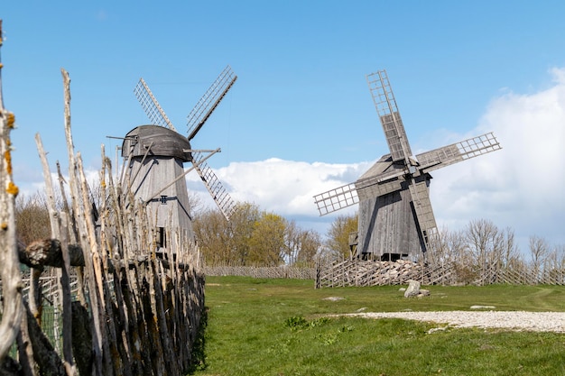 Zdjęcie dwa drewniane młyny wiatrowe z drewnianym płotem na niebieskim tle